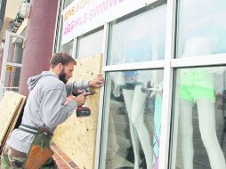 Muchas personas colocaron cinta adhesiva en los cristales de sus casas y locales comerciales, para protegerse contra ''Sandy''. AP  /