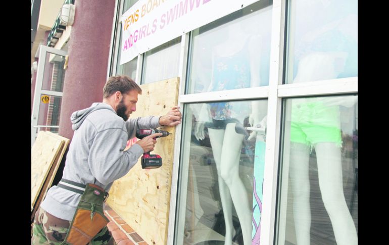 Muchas personas colocaron cinta adhesiva en los cristales de sus casas y locales comerciales, para protegerse contra ''Sandy''. AP  /