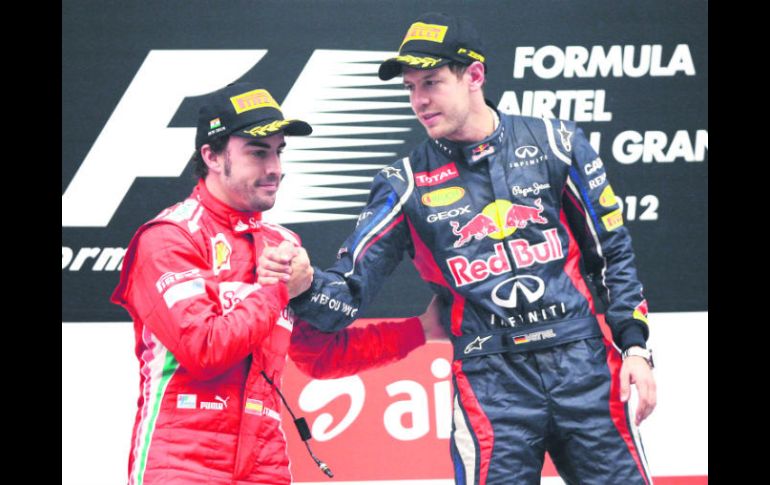 Hasta la próxima. Sebastian Vettel (der.) y Fernando Alonso se saludan, tras la carrera en la pista de Buddh. AP  /