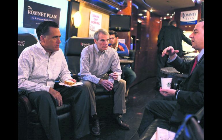 Mitt Romney con miembros de su equipo abordo del autobús de campaña. AFP  /