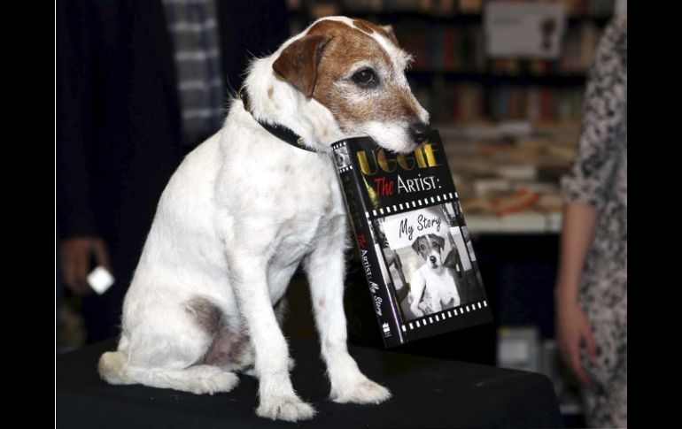 Uggie, sosteniendo su biografía durante la presentación del libro en Londres. AP  /