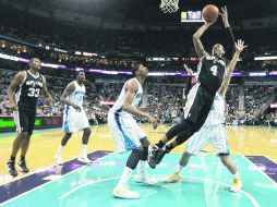 Presionado. Danny Green (4), de los Spurs, tira a la canasta ante la marca de los jugadores de Nueva Orleans.  REUTERS  /