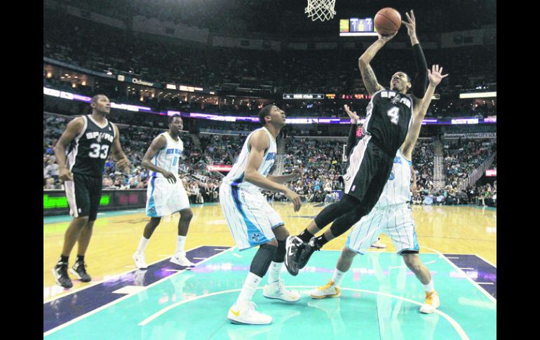 Presionado. Danny Green (4), de los Spurs, tira a la canasta ante la marca de los jugadores de Nueva Orleans.  REUTERS  /