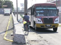 Entre el tráfico, peatones y ciclistas tienen que pegarse a la pared del paso a desnivel tanto como puedan.  /