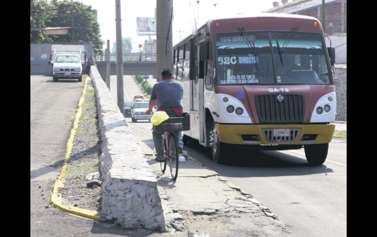 Entre el tráfico, peatones y ciclistas tienen que pegarse a la pared del paso a desnivel tanto como puedan.  /