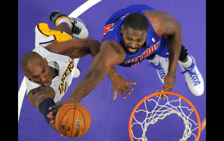 Kobe Bryant (i) intenta encestar mientras Jason Maxiell defiende. AP  /