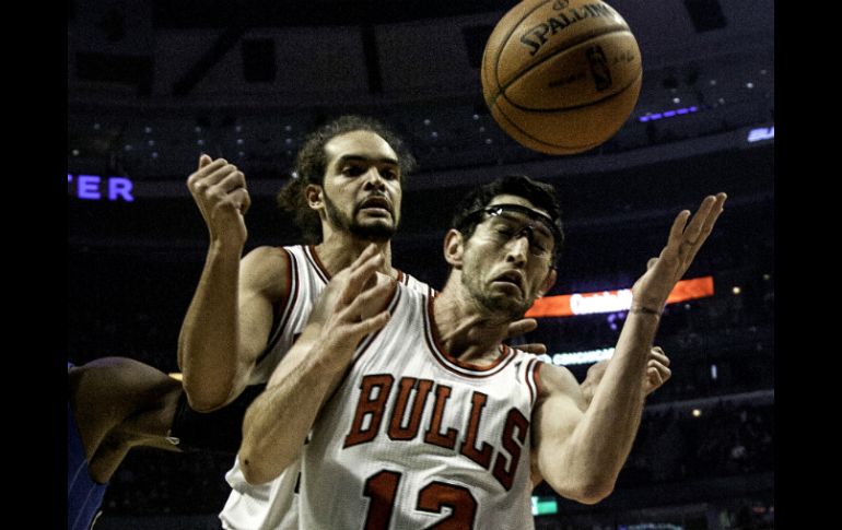 Kirk Hinrich (12) intenta salvar un balón ante Joakim Noah. AP  /