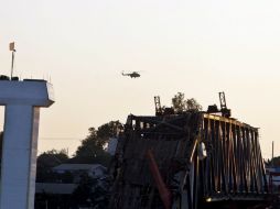 Un helicóptero vuela sobre el puente Yatanar Teinga que  se derrumbó tras el movimiento telúrico. EFE  /