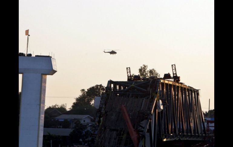 Un helicóptero vuela sobre el puente Yatanar Teinga que  se derrumbó tras el movimiento telúrico. EFE  /