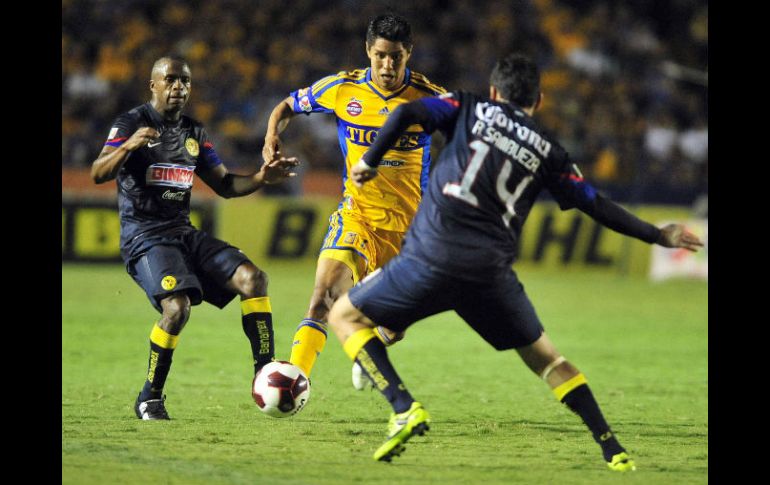 Hugo Ayala (c) de Tigres disputa el balón con Christian Benitez (i) y Rubens Sambueza (d) de América. EFE  /