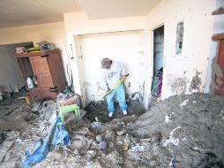 Limpieza. Un hombre retira los desechos arrojados al interior de su vivienda por la fuerza de ''Sandy'', en Long Beach. XINHUA  /