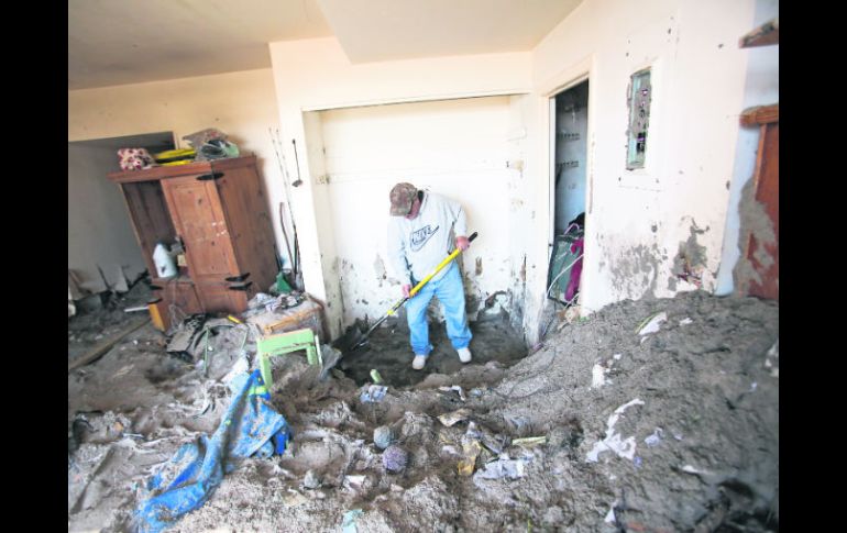 Limpieza. Un hombre retira los desechos arrojados al interior de su vivienda por la fuerza de ''Sandy'', en Long Beach. XINHUA  /