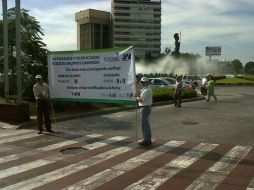 Personas con pancartas promueven la verificación vehicular, en calles que confluyen con la Glorieta Minerva.  /