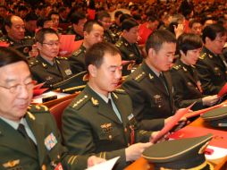 Delegados observan sus boletas durante la sesión de clausura del XVIII Congreso Nacional del Partido Comunista de China. XINHUA  /