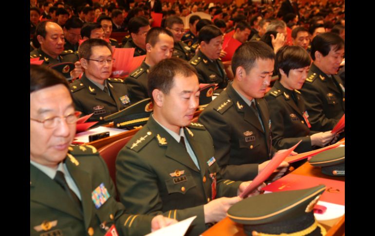 Delegados observan sus boletas durante la sesión de clausura del XVIII Congreso Nacional del Partido Comunista de China. XINHUA  /