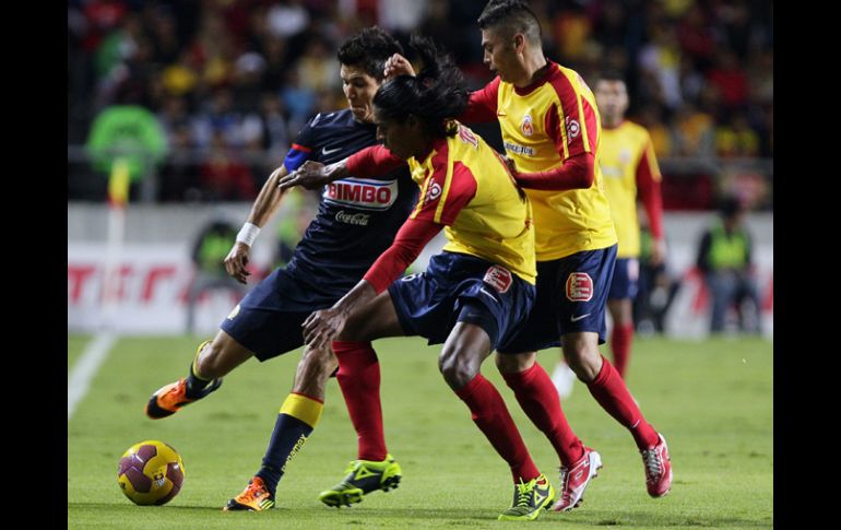 El jugador de América Jesús Molina (i) disputa el balón con Joel Adrián Huiqui (c) y Carlos Adrián Morales (d), de Monarcas. EFE  /