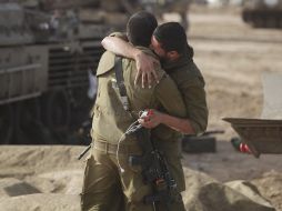 Soldados israelíes se abrazan tras instalar un campamento en la lozalidad de Sderot. EFE  /