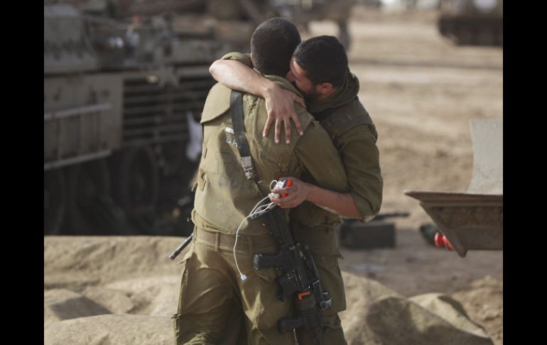 Soldados israelíes se abrazan tras instalar un campamento en la lozalidad de Sderot. EFE  /