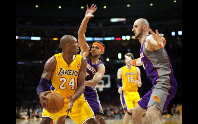 El escolta de Los Ángeles Lakers Kobe Bryant (i) presionado por Jared Dudley (c) de Marcin Gortat, de los Phoenix Suns. EFE  /