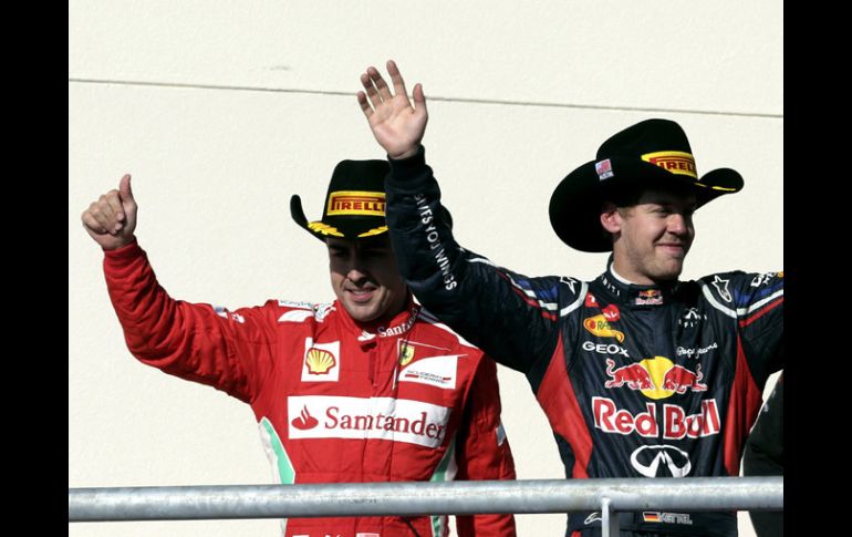 Fernando Alonso y Sebastian Vettel celebran en la ceremonia de triunfadores de Austin. AP  /