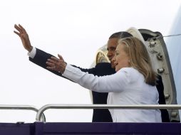 Obama y Clinton saludan al salir del avión. REUTERS  /