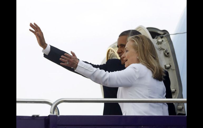 Obama y Clinton saludan al salir del avión. REUTERS  /