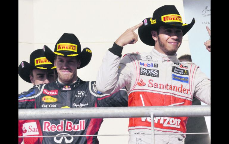 Hamilton, Vettel y Alonso arriban al podio vistiendo los tradicionales sombreros texanos para la ceremonia de premiación. AP  /