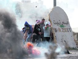 Resguardo. Jóvenes palestinos se ocultan de la ofensiva israelí cerca de la Universidad de Birzeit, en Atara. AFP  /