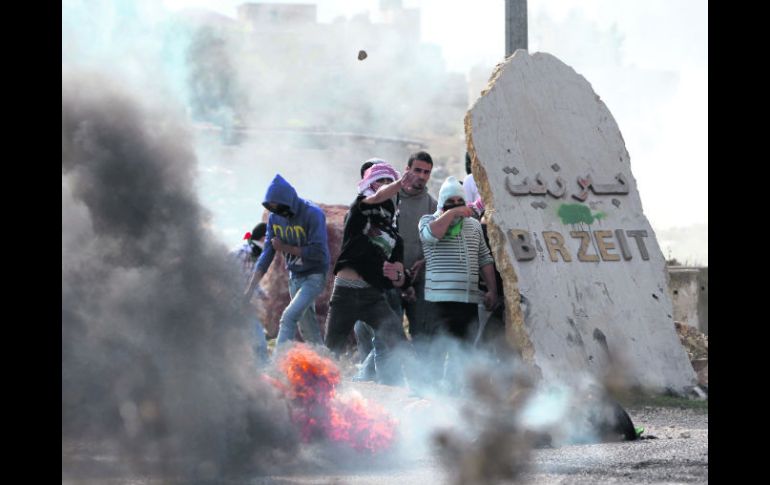 Resguardo. Jóvenes palestinos se ocultan de la ofensiva israelí cerca de la Universidad de Birzeit, en Atara. AFP  /