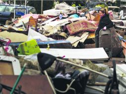 Residentes de Staten Island todavía levantan los escombros en que quedaron convertidas sus viviendas tras el paso de ''Sandy''.ESPECIAL  /