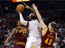 LeBron James, de los Miami Heat, es bloqueado por los jugadores del Cavaliers Tyler Zeller (d) y Alonzo Gee (i). REUTERS  /