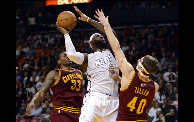 LeBron James, de los Miami Heat, es bloqueado por los jugadores del Cavaliers Tyler Zeller (d) y Alonzo Gee (i). REUTERS  /