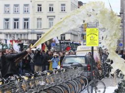 Los productores bloquean el tránsito en la capital belga con tractores y rocian la leche sobre la sede del Parlamento Europeo. EFE  /