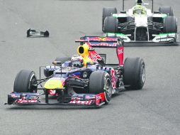 Rumbo a la corona. Sebastian Vettel elude residuos del auto de Mark Webber, durante la última carrera del año en Interlagos. AP  /