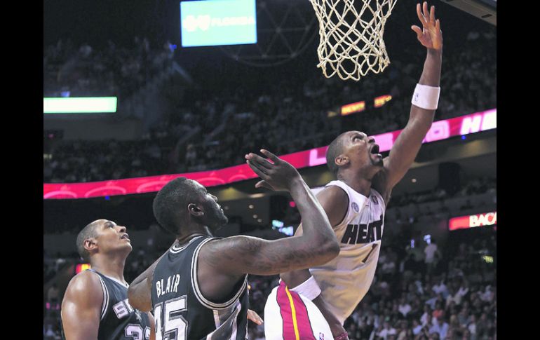 Con permiso. Chris Bosh ataca la canasta, ante la marca de los Spurs. AFP  /