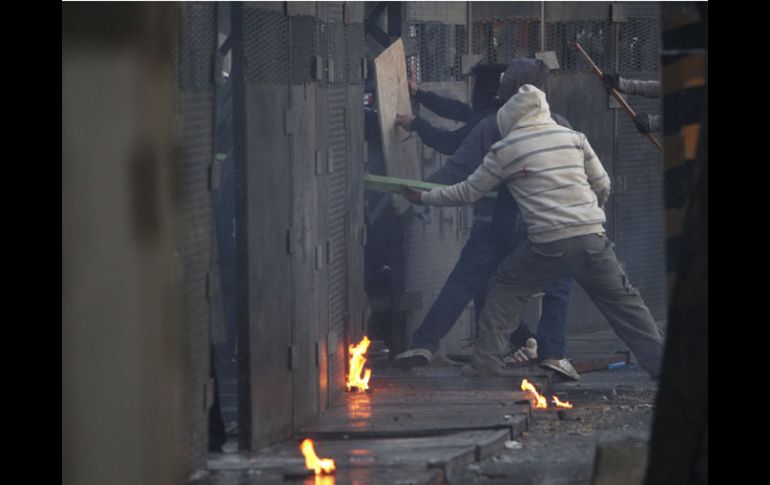 Manifestantes tratan de derribar las barricadas policiales. REUTERS  /