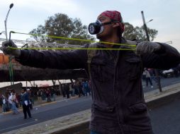 Un residente se enfrenta a la policía previo a la ceremonia protocolaria de la toma de protesta de Peña Nieto. XINHUA  /