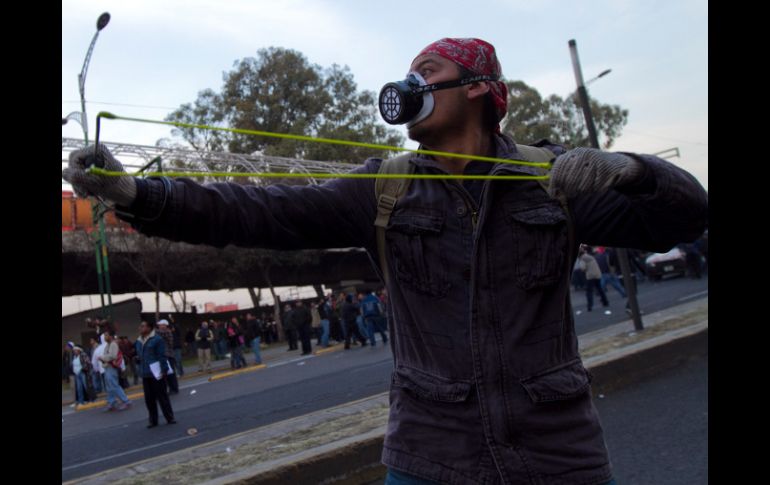 Un residente se enfrenta a la policía previo a la ceremonia protocolaria de la toma de protesta de Peña Nieto. XINHUA  /