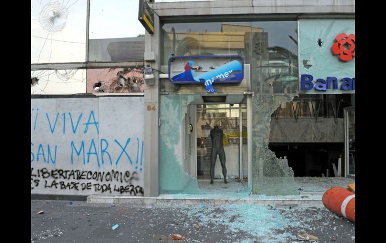 Manifestantes atacaron con palos y piedras bancos, hoteles, restaurantes y otros comercios. AFP  /