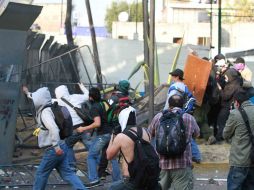 Grupo de jóvenes encapuchados intentaron romper el cerco metálico alrededor de San Lázaro, lanzando bombas Molotov. NOTIMEX  /