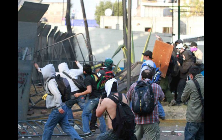 Grupo de jóvenes encapuchados intentaron romper el cerco metálico alrededor de San Lázaro, lanzando bombas Molotov. NOTIMEX  /