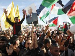 Palestinos ondean banderas nacionales y del presidente Abás, a su llegada a Ramala. AP  /