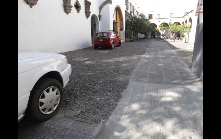 La rampa tiene el símbolo de la silla de ruedas, pero éste no tiene el típico color amarillo, es gris como el cemento.  /