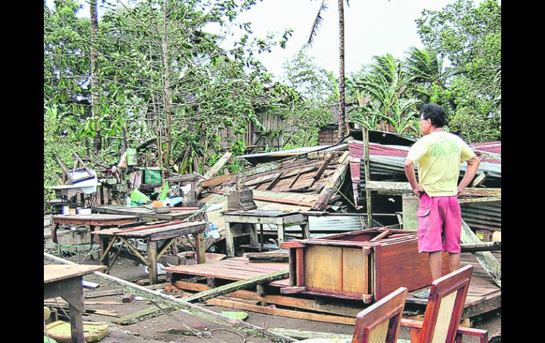 Destrozos. Un hombre observa los restos de su casa destruida por los vientos causados por el meteoro en la Ciudad de Butuan. AFP  /