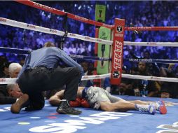 Pacquiao yace en el ring mientras el referi, Kenny Bayless, se arrodilla a su lado. AP  /