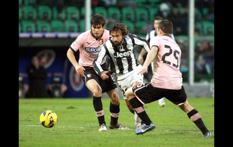 Andrea Pirlo se quita la marca de dos jugadores del Palermo en el partido. EFE  /