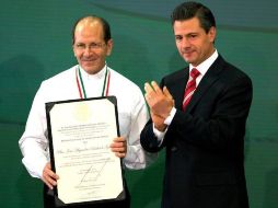 El padre Alejandro Solalinde (i) recibe el reconocimiento de parte del Presidente Peña Nieto. ESPECIAL  /