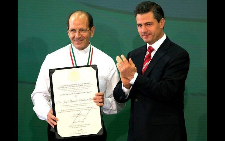 El padre Alejandro Solalinde (i) recibe el reconocimiento de parte del Presidente Peña Nieto. ESPECIAL  /