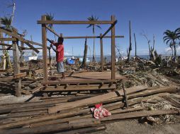 Un hombre filipino trata dereconstruir su casa, tras el paso del tifón. EFE  /