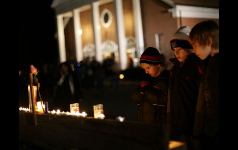 Tres niños observan las luces de veladoras encendidas afuera de un templo. REUTERS  /